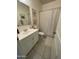 Bright bathroom features a white single sink vanity, neutral tile floor, and tub with shower at 3602 N 300Th Dr, Buckeye, AZ 85396