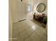 Inviting entryway featuring neutral tile flooring and a decorative console table with a round mirror at 3602 N 300Th Dr, Buckeye, AZ 85396