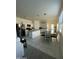 Open concept kitchen and dining area with stainless steel appliances, white cabinets, and tile flooring at 3602 N 300Th Dr, Buckeye, AZ 85396