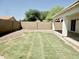 A spacious backyard featuring a grassy lawn, gravel accents, and a block fence at 365 E Mountain View Rd, San Tan Valley, AZ 85143