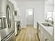 Bright kitchen featuring stainless steel appliances, white cabinets, quartz countertops, and stylish wood floors at 365 E Mountain View Rd, San Tan Valley, AZ 85143