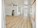 Spacious living room featuring bright white walls, light wood-look flooring, and a view into the kitchen and backyard at 365 E Mountain View Rd, San Tan Valley, AZ 85143