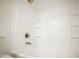 Bright tub and shower combo features sleek hardware, storage shelves and white tile surround at 365 E Mountain View Rd, San Tan Valley, AZ 85143