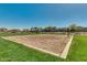 Sandy volleyball court set in a green park with houses in the background, perfect for outdoor recreation at 365 E Mountain View Rd, San Tan Valley, AZ 85143