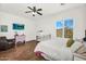 Relaxing bedroom features a comfortable bed, ceiling fan, television, and window with bright natural light at 37308 N 100Th Pl, Scottsdale, AZ 85262