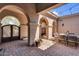 Outdoor dining set inside charming, arched courtyard with string lights overhead at 37308 N 100Th Pl, Scottsdale, AZ 85262