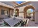 Outdoor dining area with shaded seating inside gated and arched courtyard at 37308 N 100Th Pl, Scottsdale, AZ 85262
