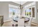 Cozy dining room features chandelier, white chairs, and views from many windows at 37308 N 100Th Pl, Scottsdale, AZ 85262