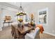 Bright dining room features a large wood table, wicker chairs, statement light fixture, and natural light at 37308 N 100Th Pl, Scottsdale, AZ 85262