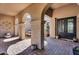 Courtyard with arched entryway leads to front door and outdoor dining area at 37308 N 100Th Pl, Scottsdale, AZ 85262