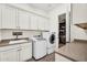 Well-equipped laundry room with sink, modern washer and dryer, and ample cabinet space at 37308 N 100Th Pl, Scottsdale, AZ 85262