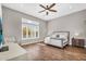 Spacious main bedroom with wood floors, ceiling fan, plantation shutters, and decorative chair at 37308 N 100Th Pl, Scottsdale, AZ 85262