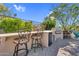 Outdoor kitchen includes a built-in grill, bar seating, and a mini-fridge, perfect for backyard entertaining at 37308 N 100Th Pl, Scottsdale, AZ 85262