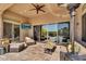 Beautiful covered patio with ample seating, ceiling fan, tv and view of the pool at 37308 N 100Th Pl, Scottsdale, AZ 85262