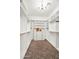 Spacious walk-in closet boasts custom shelving and cabinets with elegant chandelier lighting and neutral tile flooring at 37308 N 100Th Pl, Scottsdale, AZ 85262