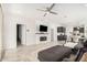 Open-concept living room featuring a modern fireplace, sleek tile flooring, and views into the kitchen and dining area at 3907 E Archer Dr, San Tan Valley, AZ 85140