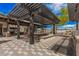 Outdoor grill area with pergola, built-in seating, modern barbecue equipment, and checkered pavement under sunny skies at 3907 E Archer Dr, San Tan Valley, AZ 85140