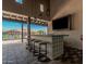 Modern poolside bar featuring a patterned tile counter, hanging pendant lights, and a mounted television for entertainment at 3907 E Archer Dr, San Tan Valley, AZ 85140