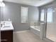 Bathroom featuring double sinks, shower, and tub at 4056 E Devon Dr, Gilbert, AZ 85296