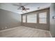 Inviting bedroom with a ceiling fan, three windows, and light-colored laminate flooring at 40741 N Citrus Canyon Trl, Anthem, AZ 85086
