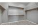 An empty walk-in closet with multiple levels of shelving and light vinyl flooring at 40741 N Citrus Canyon Trl, Anthem, AZ 85086