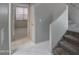 Modern hallway with view of stairs, light tile flooring, and view into open bedroom at 40741 N Citrus Canyon Trl, Anthem, AZ 85086