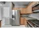 Well-lit kitchen featuring stainless steel appliances, light wood cabinets, and a clean white tile floor at 40741 N Citrus Canyon Trl, Anthem, AZ 85086