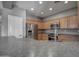 Galley style kitchen with stainless steel appliances, wood cabinets, and a breakfast bar area at 40741 N Citrus Canyon Trl, Anthem, AZ 85086