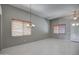 Open living room with neutral paint, tile flooring, lots of natural light, and a decorative light fixture at 40741 N Citrus Canyon Trl, Anthem, AZ 85086