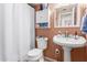 Compact bathroom featuring a toilet, sink, medicine cabinet, and shower with curtain at 4218 S 46Th Pl, Phoenix, AZ 85040