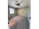 This bedroom features neutral walls, carpet, a ceiling fan, and a window for natural light at 6808 W Maldonado Rd, Laveen, AZ 85339