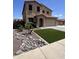 Landscaped front yard with rocks, turf, and palm trees create an inviting curb appeal at 6808 W Maldonado Rd, Laveen, AZ 85339