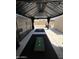 Covered outdoor game area features cornhole game and relaxing black curtains at 6808 W Maldonado Rd, Laveen, AZ 85339
