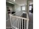 Upstairs hallway with white railing and view of bedrooms and carpeted floors at 6808 W Maldonado Rd, Laveen, AZ 85339