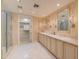 A bright bathroom with double sinks, marble countertops, walk-in shower, and an open closet offer luxury and functionality at 7175 E Camelback Rd # 902, Scottsdale, AZ 85251