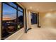 A spacious bedroom features stunning city views through large windows, complemented by elegant drapery and neutral carpeting at 7175 E Camelback Rd # 902, Scottsdale, AZ 85251