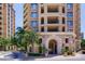 Elegant apartment building exterior showing a stone arch entrance, balconies, and lush landscaping at 7175 E Camelback Rd # 902, Scottsdale, AZ 85251
