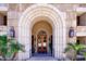 Elegant building entrance with arched stone facade, ornate doors, and well-maintained landscaping at 7175 E Camelback Rd # 902, Scottsdale, AZ 85251