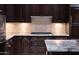 Gourmet kitchen with gas cooktop, granite counters, and custom wood cabinetry at 7175 E Camelback Rd # 902, Scottsdale, AZ 85251