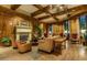 Cozy living room with hardwood floors, wood beams, a fireplace, and comfortable seating at 7175 E Camelback Rd # 902, Scottsdale, AZ 85251