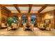 Elegant lounge area featuring wood paneling, arched windows, seating, and a large indoor plant at 7175 E Camelback Rd # 902, Scottsdale, AZ 85251
