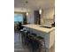 Modern kitchen featuring a sleek island with bar seating, stylish pendant lighting, and stainless steel appliances at 7635 E Verde Ln, Scottsdale, AZ 85251