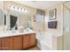 Bathroom featuring a double sink vanity, soaking tub, and walk-in glass shower at 7734 W Terri Lee Dr, Phoenix, AZ 85035