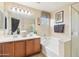 Well-lit bathroom with double sinks, bathtub, a shower and decorative fixtures at 7734 W Terri Lee Dr, Phoenix, AZ 85035