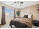 Cozy bedroom with plush bedding, a ceiling fan, and natural light from the window at 7734 W Terri Lee Dr, Phoenix, AZ 85035
