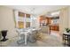 Bright dining area showcases a modern white table and open access to a well-equipped kitchen at 7734 W Terri Lee Dr, Phoenix, AZ 85035