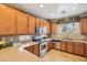 Well-maintained kitchen featuring stainless steel appliances, wooden cabinetry, and tile backsplash at 7734 W Terri Lee Dr, Phoenix, AZ 85035