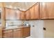 Laundry room with wooden cabinets, a sink, and decorative fixtures at 7734 W Terri Lee Dr, Phoenix, AZ 85035