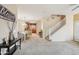 Open concept living room with plush carpeting, dining area, and staircase leading to upper level at 7734 W Terri Lee Dr, Phoenix, AZ 85035