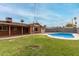 Spacious backyard featuring a refreshing pool, lush lawn, and covered patio area at 8716 E Holly St, Scottsdale, AZ 85257